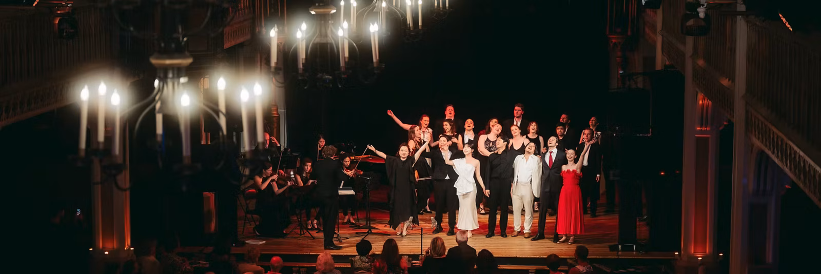 Chanteurs sur scène à droite d'une orchestre